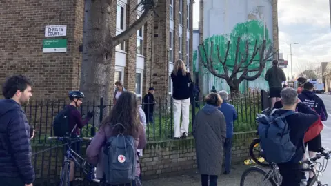 Ella Nunn/PA Wire Crowd of people standing in front of Banksy mural