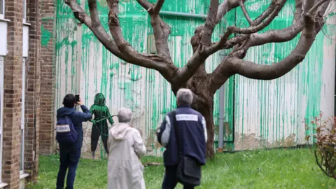 EPA People view Banksy's artwork near a tree on Hornsey Road in the Finsbury Park area of London