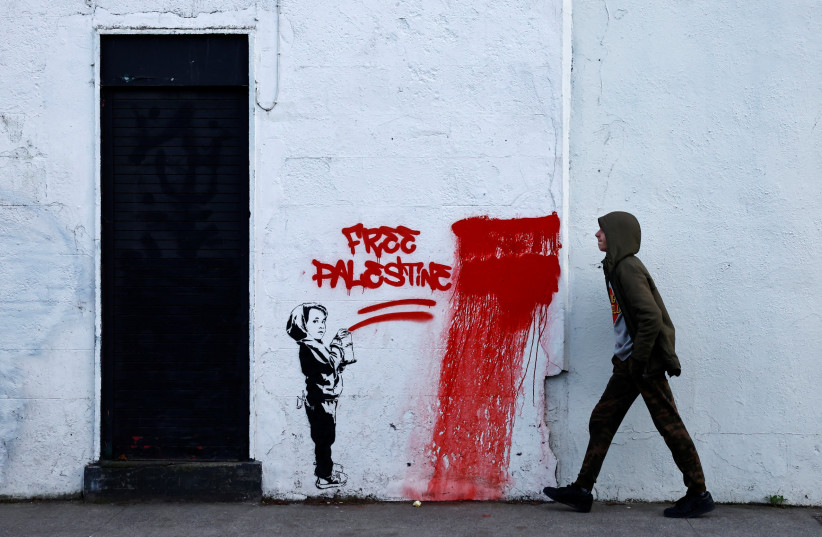  A man walks past graffiti reading 'Free Palestine', amid the ongoing conflict between Israel and the Palestinian Islamist group Hamas, in Dublin, Ireland, November 15, 2023. (credit: REUTERS/CLODAGH KILCOYNE)