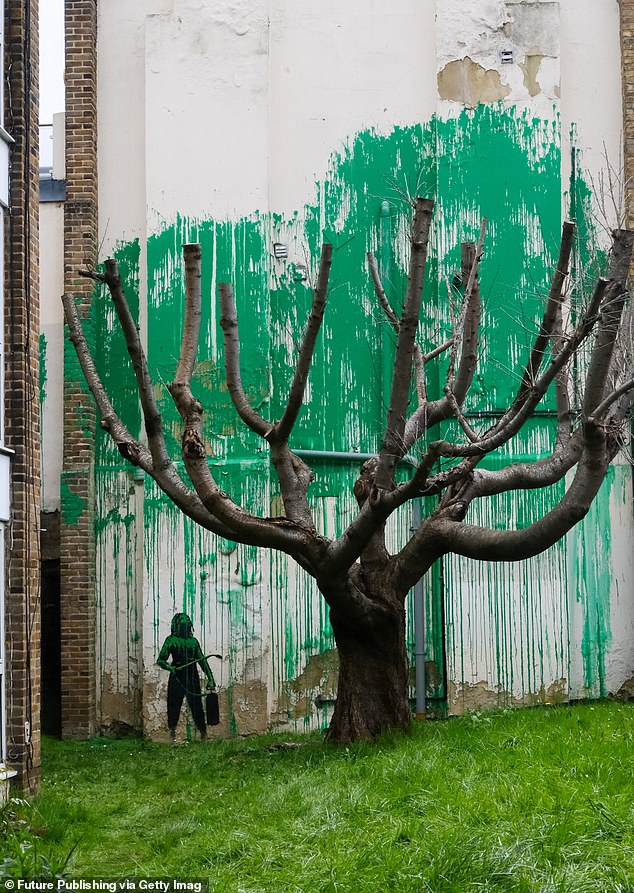 It has been confirmed that the north London mural above, a splattering of green paint behind a bare tree to resemble foliage, with a stencil of a person holding a pressure hose depicted next to it, is a Banksy