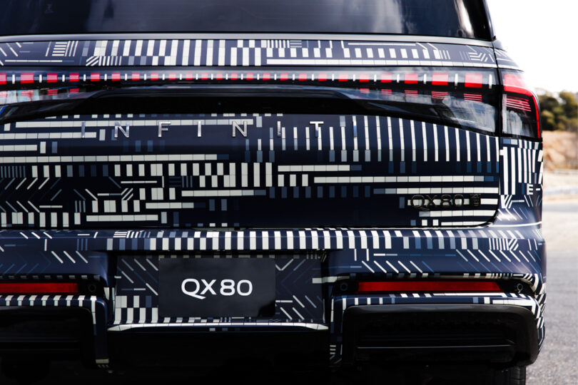 Rear right corner section of the new Infiniti GX80 wrapped in a monochromatic dash and square pattern designed by digital artist Kaoru Tanaka with 