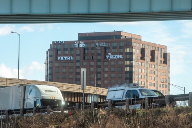 Traffic travels along I-84 in Hartford as graffiti covers the top of 25 Sigourney St.(Aaron Flaum/Hartford Courant)
