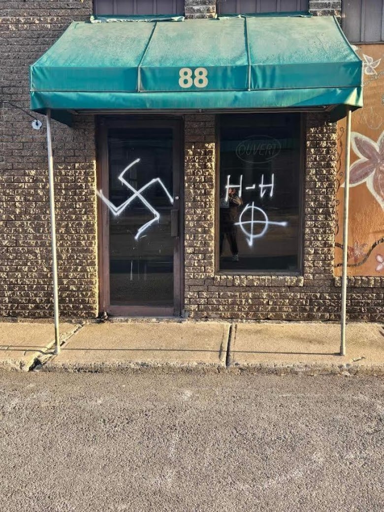 A door is painted with a swastika.