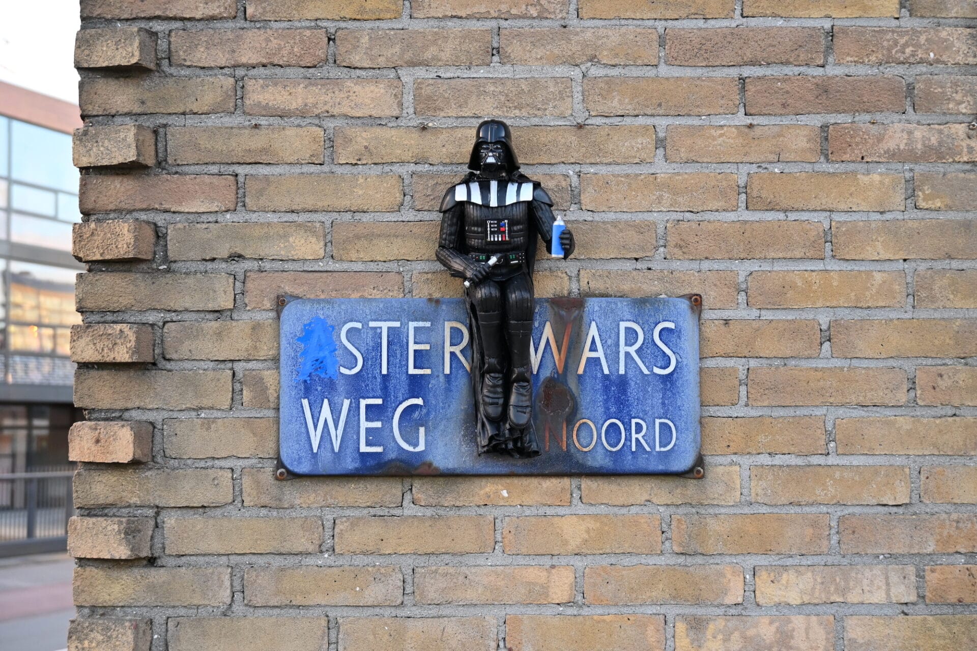 A sculpture of Darth Vader is placed onto a sign that reads