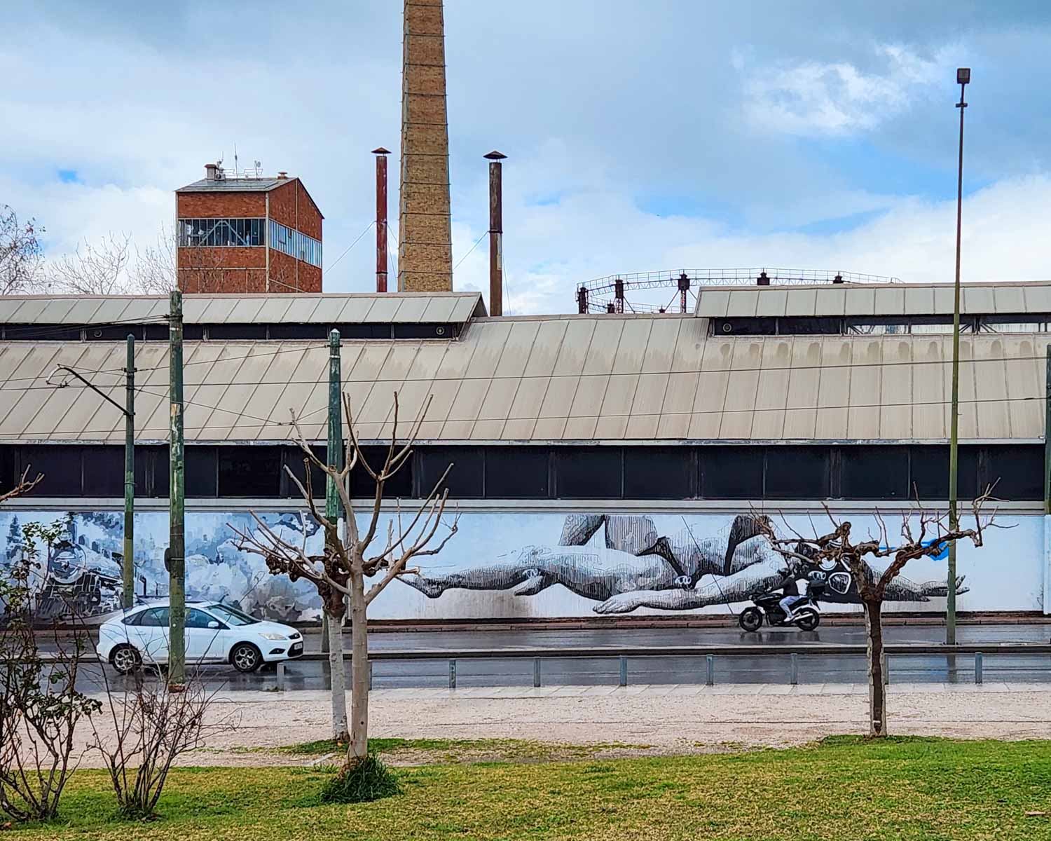 View towards a piece of street art in Gazi by INO of a woman in a bikini and gas mask - my street art tour of Athens review