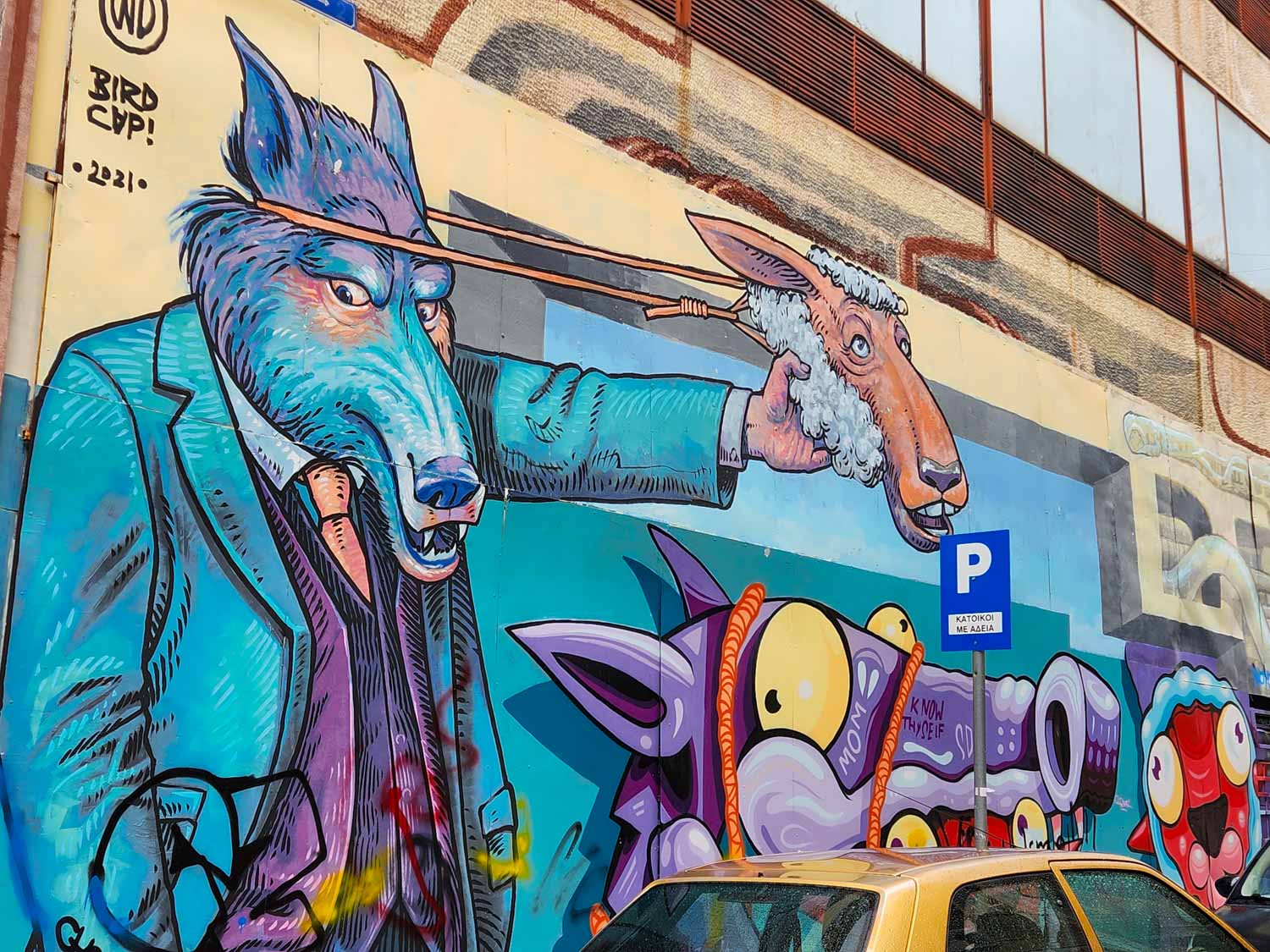 Street art of a wolf in a suit pulling a sheep's mask off his face - one of the artworks we saw on a street art tour of Athens with kids