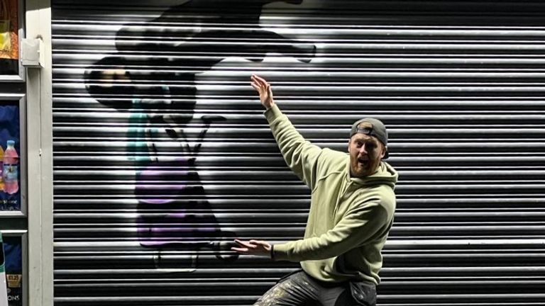 Graffiti artist Tee2Sugars next to his mural in Rhondda Cynon Taf.