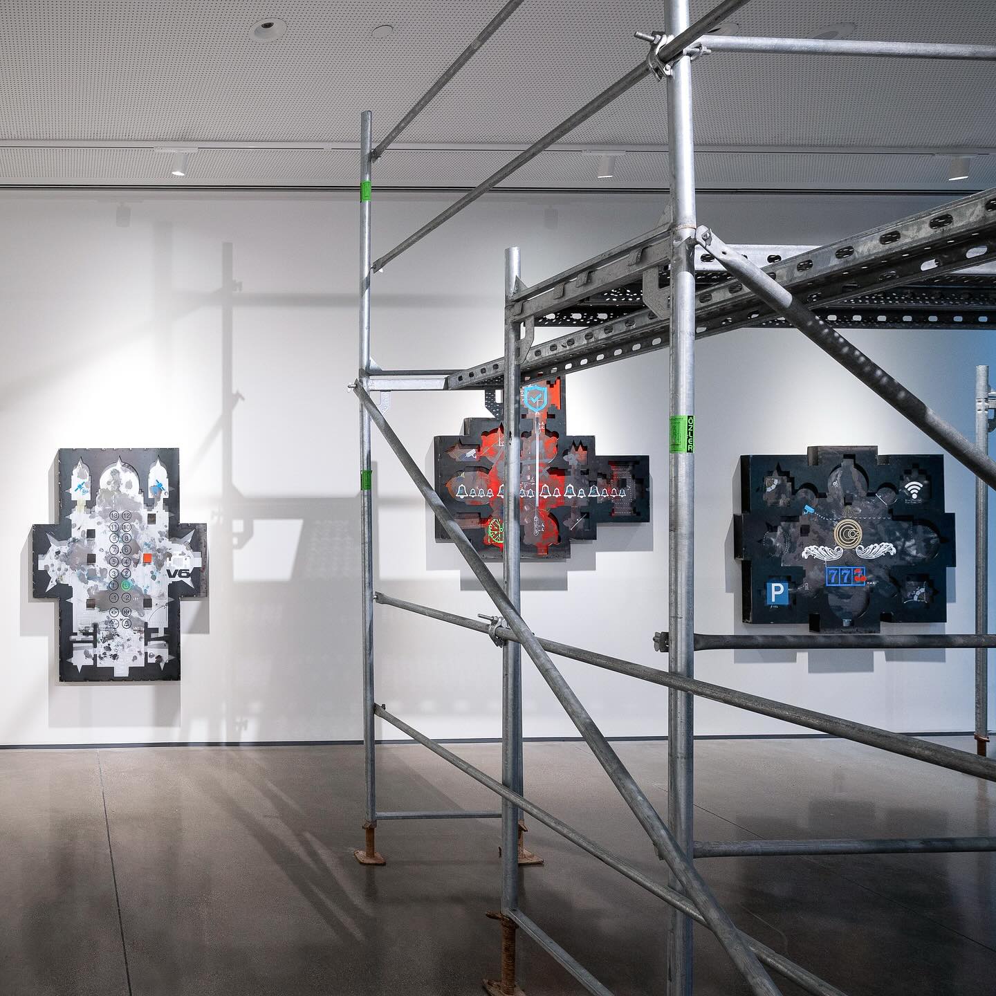 The interior of an art gallery with a scaffolding in the center of the floor