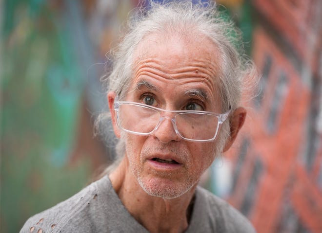 Tom Bauman helps restore the “Austintatious” mural he originally painted with Kerry Awn and Rick Turner as University of Texas art students in 1973, on the north wall of the University Co-Op Monday April 1, 2024.