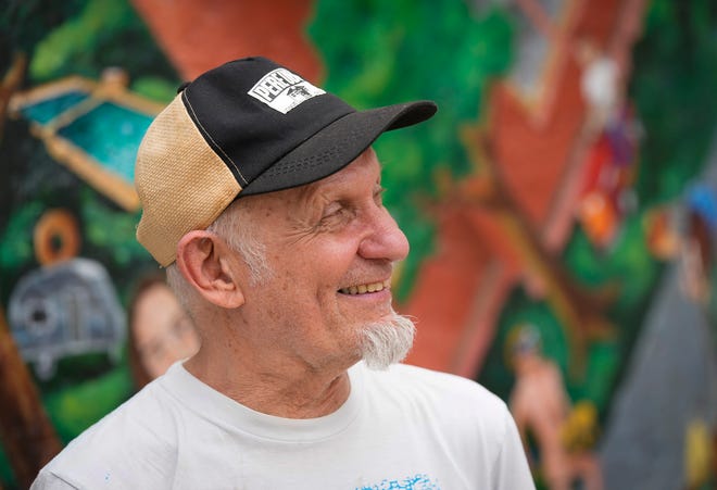 Rick Turner helps restore the “Austintatious” mural he originally painted with Kerry Awn and Tom Bauman as University of Texas art students in 1973, on the north wall of the University Co-Op Monday April 1, 2024.