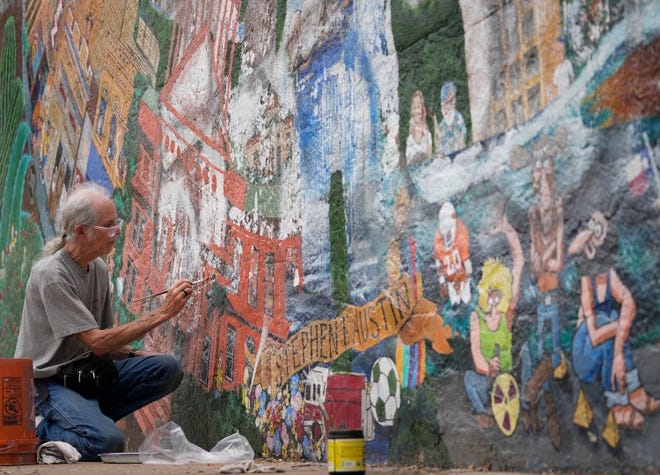 Tom Bauman helps restore the “Austintatious” mural he originally painted with Kerry Awn, and Rick Turner as University of Texas art students in 1973, on the north wall of the University Co-Op Monday April 1, 2024.