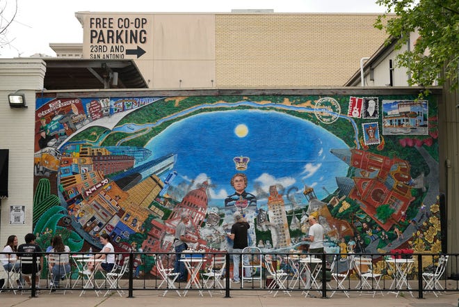 Tom Bauman, left to right, Kerry Awn and Rick Turner restore their “Austintatious” mural they originally painted as University of Texas art students in 1973, on the north wall of the University Co-Op Monday April 1, 2024.