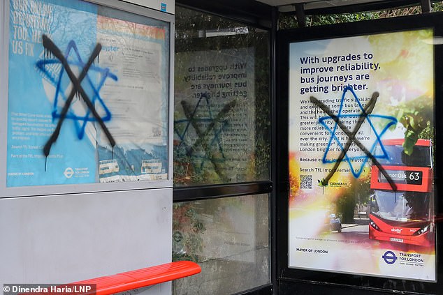 A star of David graffitied with a large black cross through it on a bus stop in Stamford Hill, north London