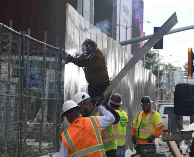 Work crews from the Quality Fence Company start putting up...
