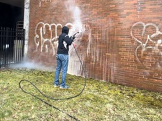 A worker begins removing graffiti from 25 Sigourney St. in Hartford. (Courtesy of Off the Wall Power Washing Specialists)